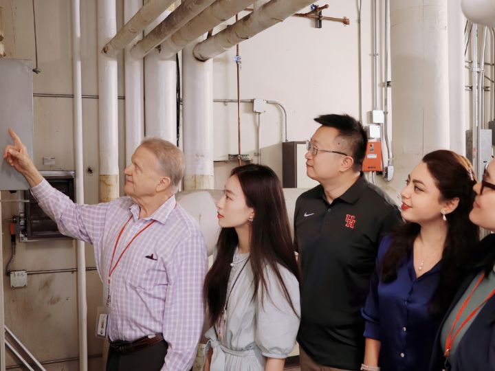 A group of people checking out power systems wires in a building.