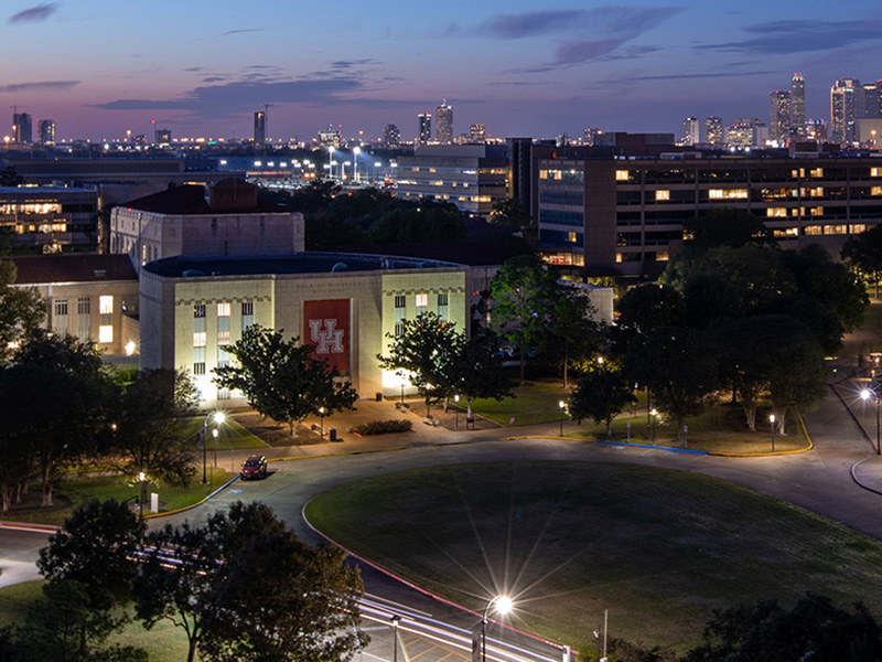 UH E Cullen Building aerial photo at night with Houston in background